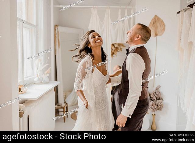 Heterosexual couple Laughing while dancing at home