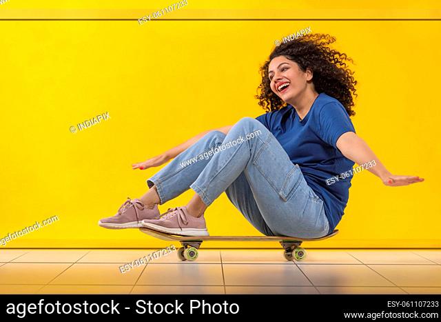 Happy woman in casual outfit skating on floor in living room
