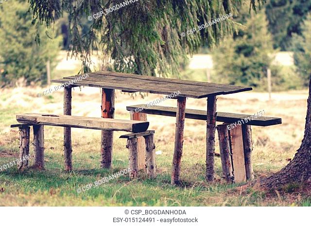Vintage photo of a Wooden, rustic bench and picnic table