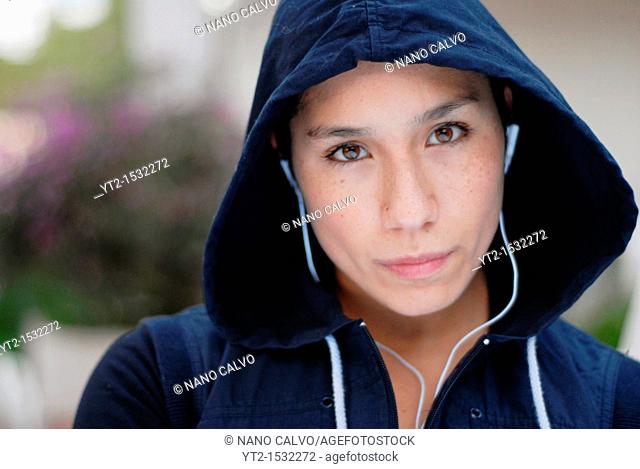 Young mixed girl, half chinese, half spanish, in her twenties, dressed with running clothes and listening to her MP3 device
