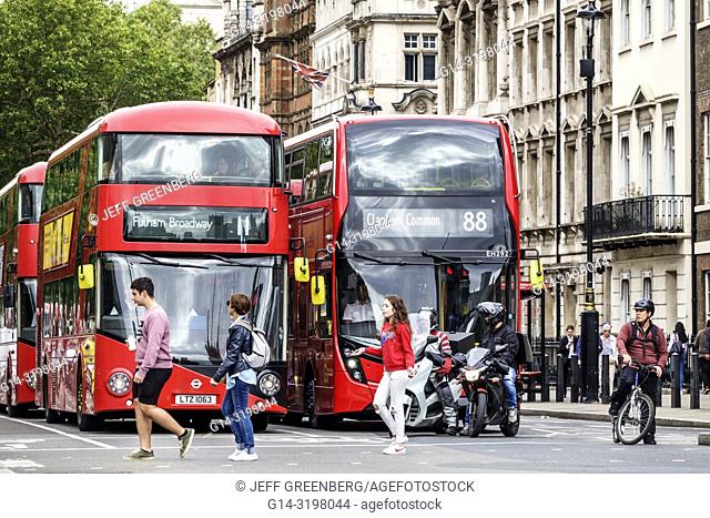 United Kingdom Great Britain England, London, Westminster, street crossing, traffic, red double-decker bus, public transportation, motorcycle, pedestrian, woman