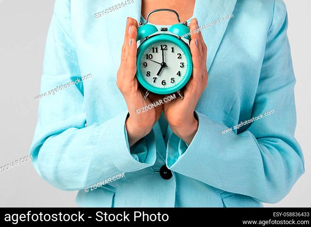 Closeup photo of woman holding clock in the hand