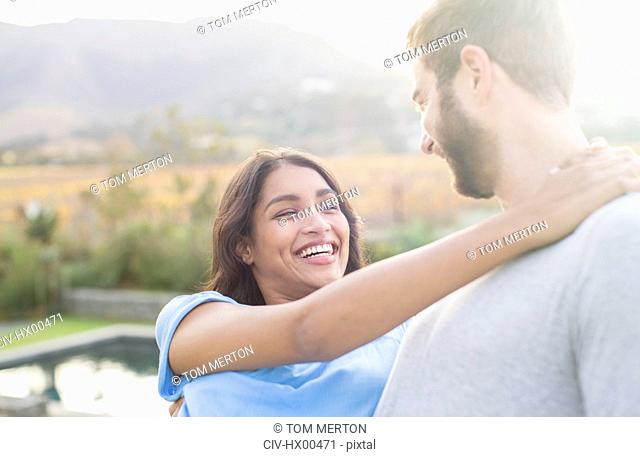 Enthusiastic couple hugging outdoors