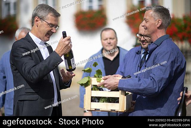 02 September 2020, Lower Saxony, Hildesheim: Heiner Wilmer (l), bishop of Hildesheim, receives the ""tithe"" from Axel Kusch from the Hildesheim wine convent