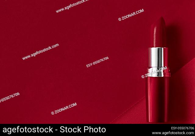 Cosmetic branding, glamour lip gloss and shopping sale concept - Luxury lipstick and silk ribbon on maroon holiday background