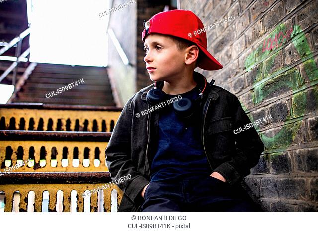 Boy sitting on metal staircase
