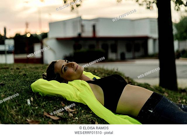 Sporty woman relaxing on grass after workout