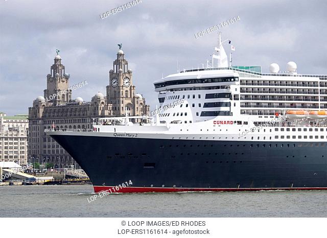 The Queen Mary 2 sailing past the Liver Buildings at the Pier Head