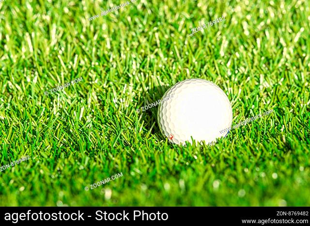 Golf ball on astro turf in bright daylight