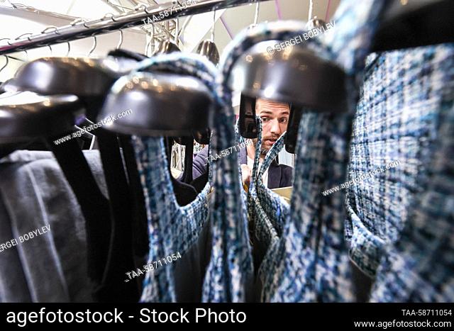 RUSSIA, MOSCOW - APRIL 28, 2023: A man looks at clothes on a clothing rack during the Moscow Fashion Week at the Oceania Shopping Centre