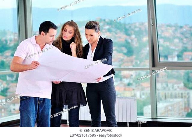 happy young couple buying new home with real estate agent