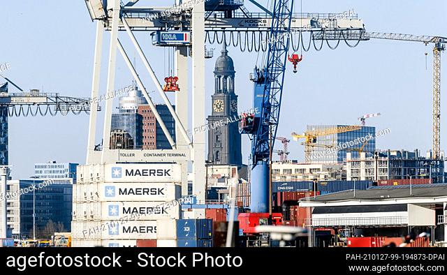 25 December 2020, Hamburg: Container cranes of the Hansa harbour, the Kehrwiederspitze and the tower of the main church St