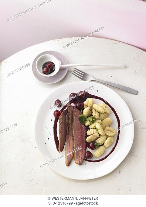 Crispy duck breast in a spicy balsamic reduction with cherries and gnocchi