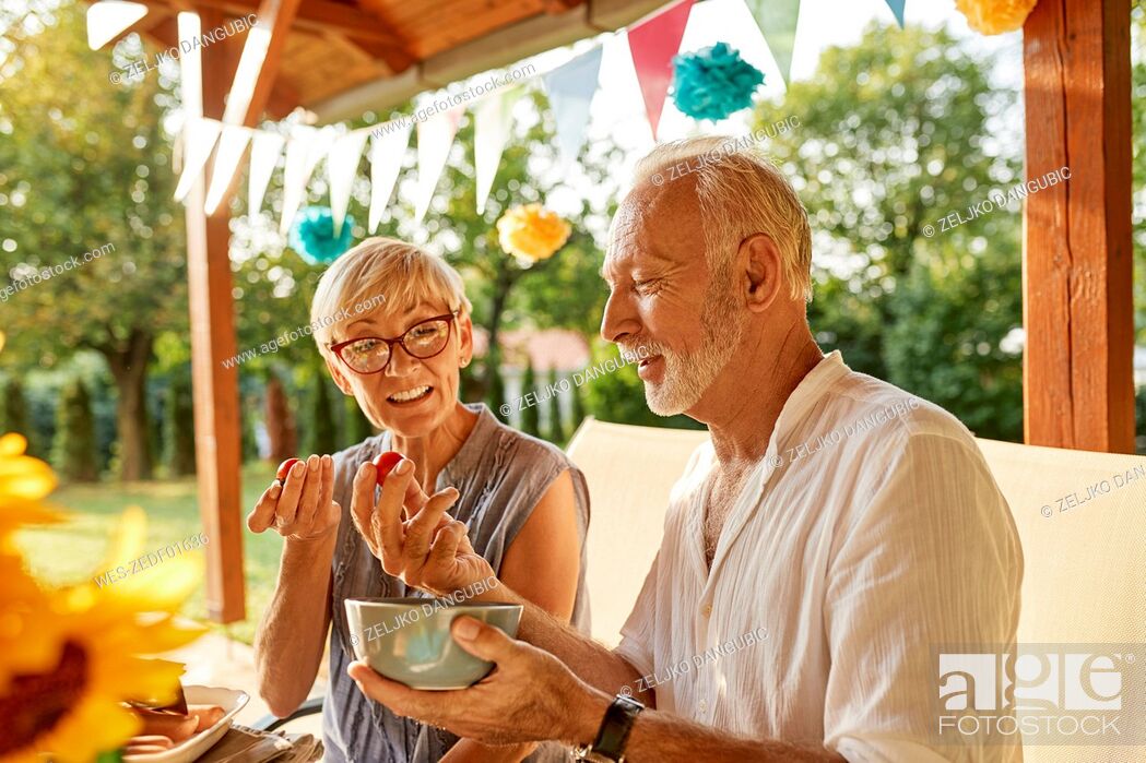 Stock Photo: Senior couple eating tomatoes on a garden party.