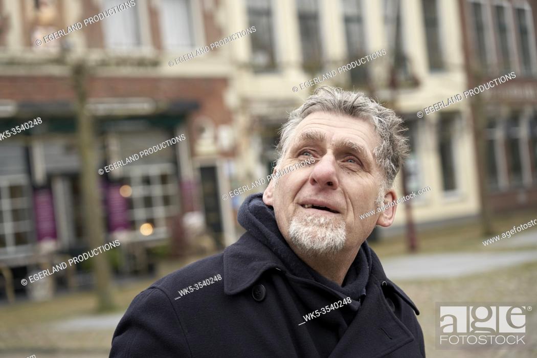 Stock Photo: curious senior man peering up in Workum, Friesland, Netherlands.