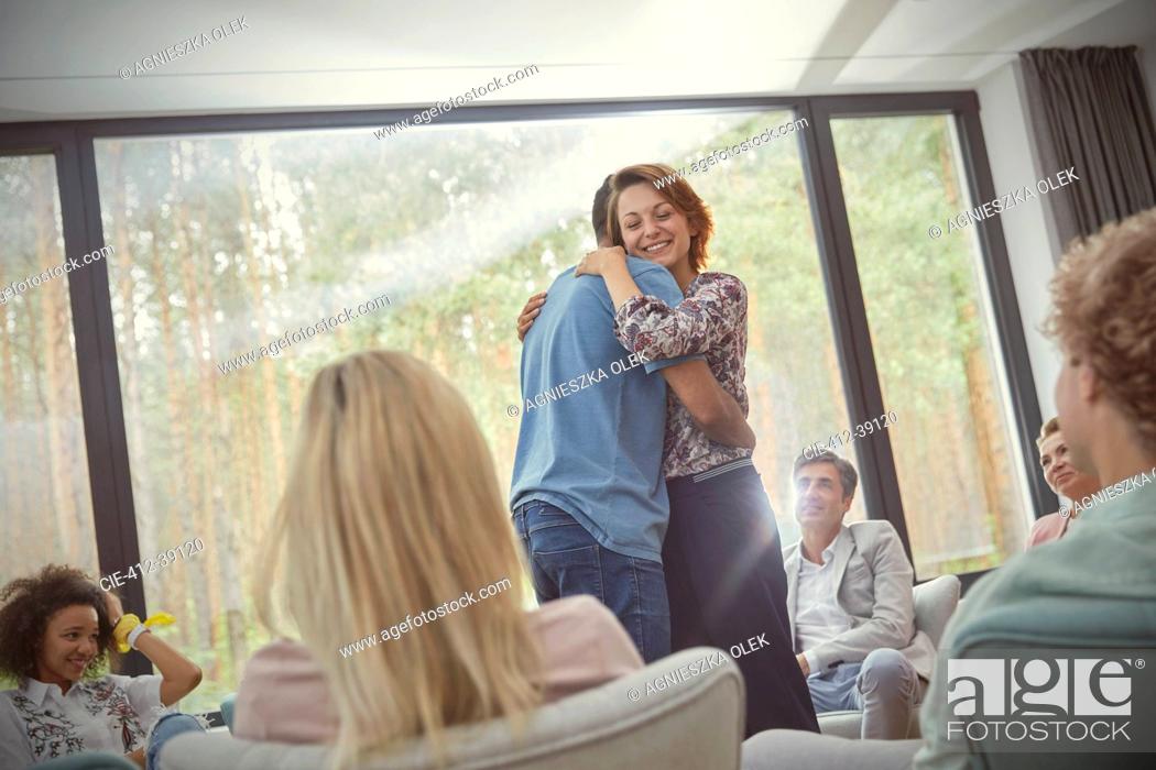Stock Photo: Man and woman hugging in group therapy session.