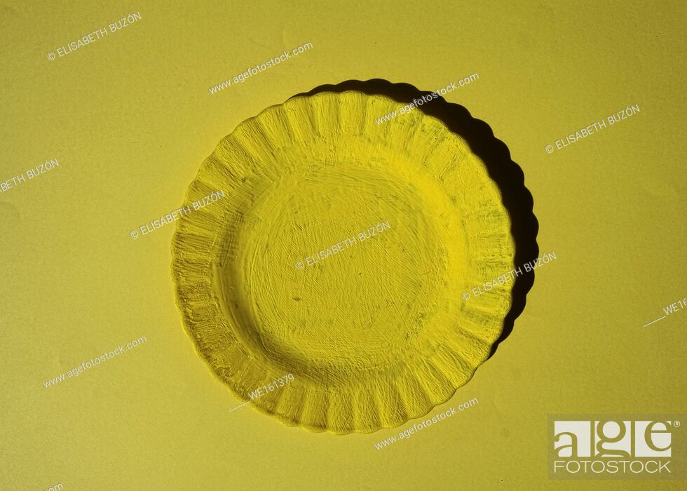 Stock Photo: Yellow plate on yellow background.