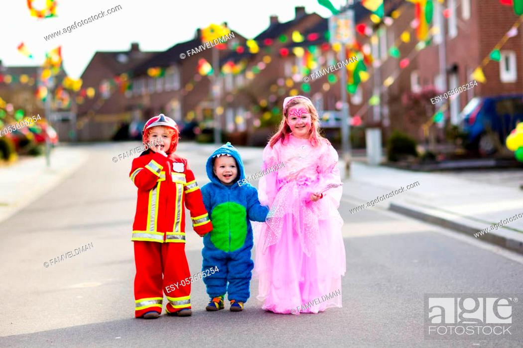Stock Photo: Kids on Halloween trick or treat. Children in Halloween costumes with candy bags walking in decorated city neighborhood trick or treating.