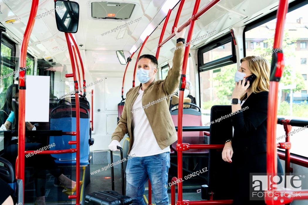 Stock Photo: Passengers wearing protective masks in public bus, Spain.