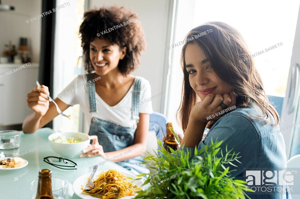 Stock Photo: Girlfriends sitting at table eating.