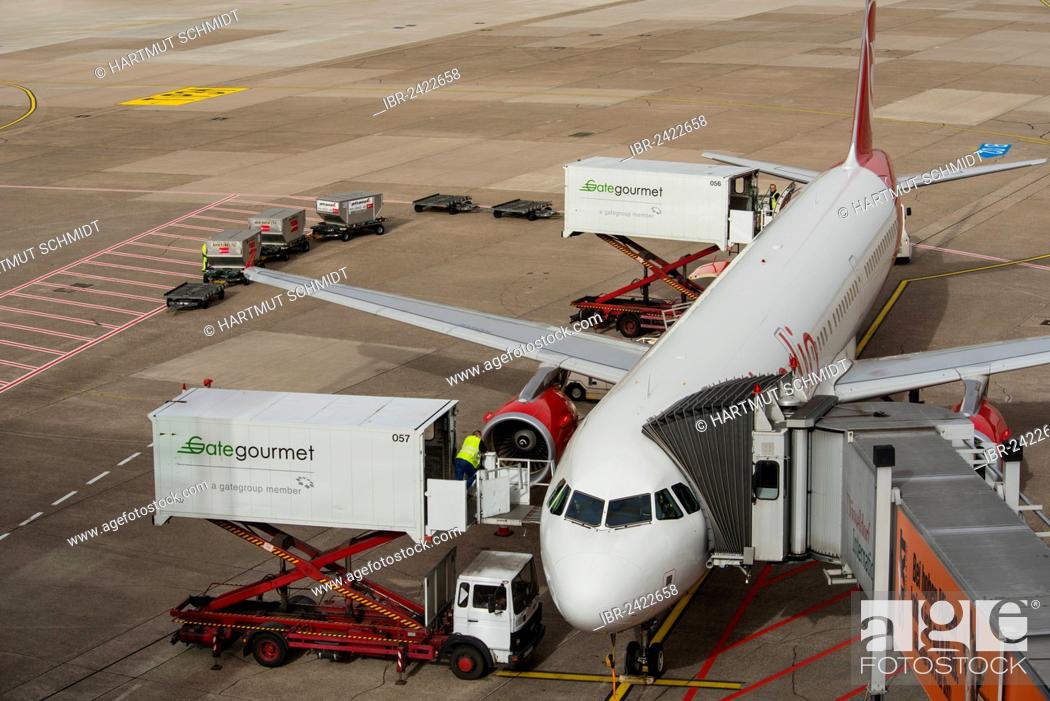 Stock Photo: Aircraft is being prepared for the flight, elevating platform truck delivering goods for the galley, baggage car and airplane gangway attached to the aircraft.